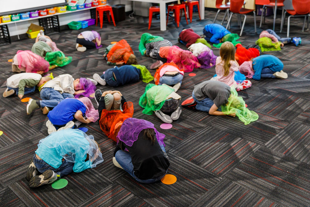 Second-grade students at Silver Lake Elementary School curl up under scarves to dance the plant life cycle.