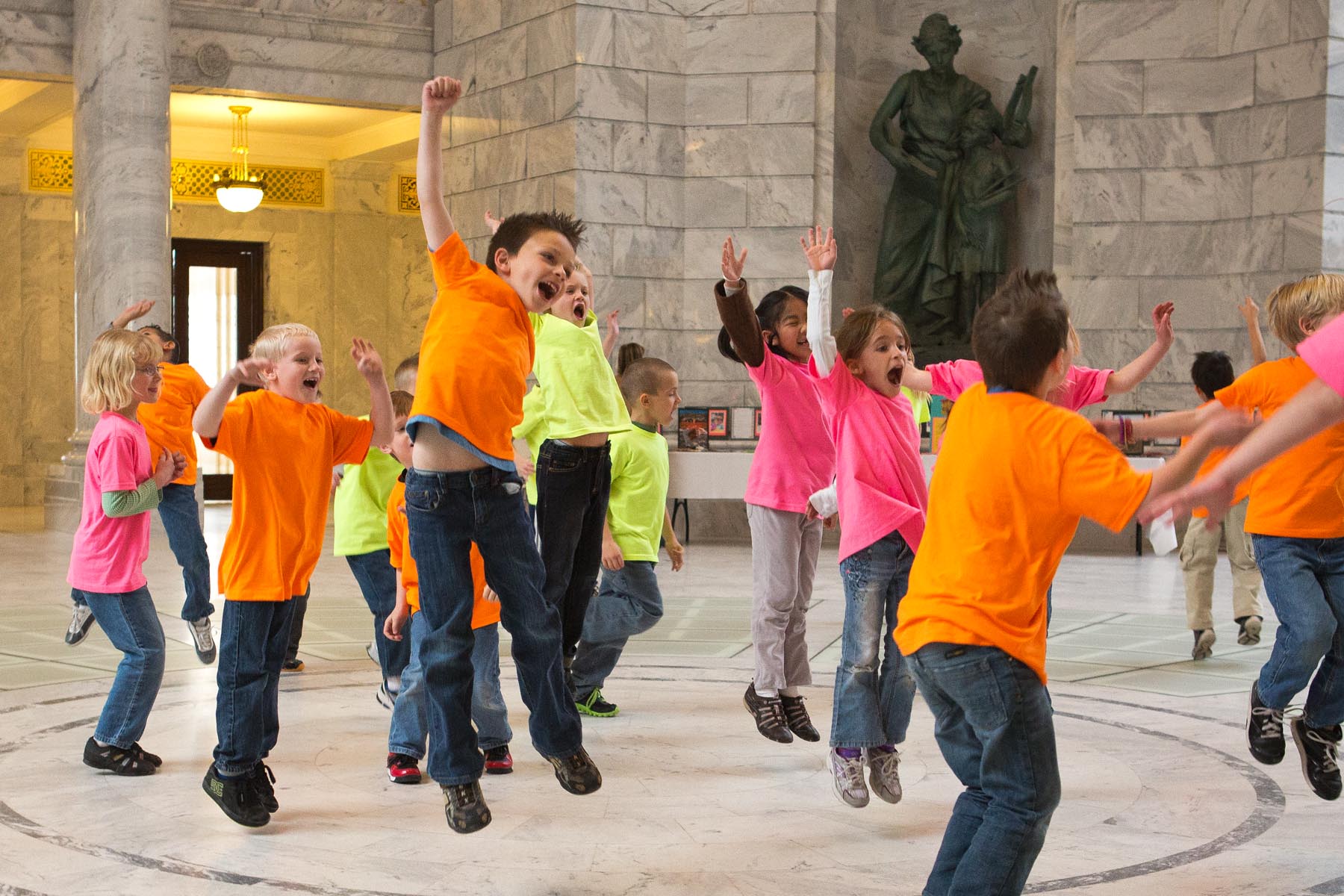 Children jumping and dancing in the Utah State Capitol building.